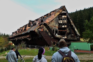 Turisti pri požiarom zničenom Hoteli Junior v lyžiarskom stredisku Jasná v Nízkych Tatrách.