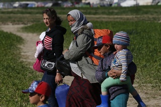 Irackí migranti nesú svoje veci pri odchode z provizórneho utečeneckého tábora pri severogréckej dedine Idomeni na macedónsko-gréckej hranici do ďalšieho tábora pri meste Katerini 12. apríla 2016.