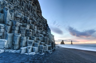 Wide view of Reynisdrangar rock formations on Reynisfjara Beach at sunrise, Halsanefhellir, Iceland.