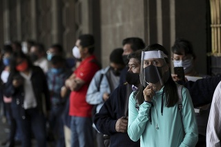 Ľudia s rúškami v rade pred úradom v Mexico City.