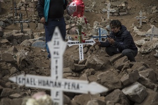 Muž smúti nad hrobom svojej starej matky, ktorá zomrela na koronavírus v Peru.
