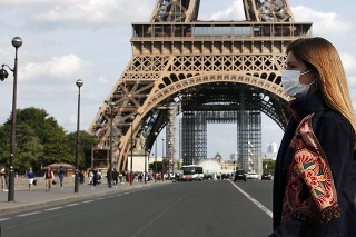Žena s ochranným rúškom pred Eiffelovou vežou