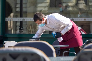 Vilnius, Lithuania - April 30 2020: Waiter with a mask disinfects the table of an outdoor bar, café or restaurant, reopen after quarantine restrictions