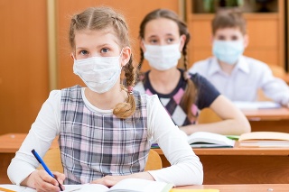 schoolkids with protection mask against flu virus at lesson