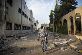Mosul, Iraq - May 23, 2017: An Iraqi security guard walks in the ruins of Al-Salam hospital, one of the many institutions in Mosul that will take years to rebuild. The hospital was the scene of heavy fighting in late 2016, when the Iraqi government, with U.S. support, wrested control of this part of Mosul from ISIS.