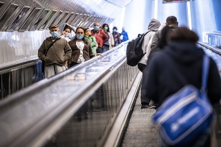  Cestujúci s ochrannými rúškami na eskalátore v Budapešti.