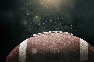 American football ball on black background illuminated
