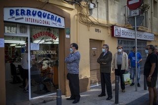Muži s ochrannými rúškami v rade pred holičstvom v Barcelone.
