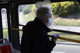 Muž s ochranným rúškom a igelitovým vreckom na hlave v pražskej električke