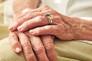 Cropped shot of an elderly woman’s hands resting on her lap