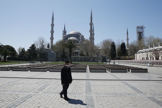Muž s ochranným rúškom kráča na vyľudnenom námestí pri Modrej mešite v tureckom Istanbule.