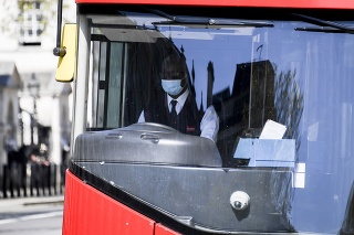 Vodič autobusu s ochranným rúškom na zabránenie šíreniu nového koronavírusu jazdí v Londýne.