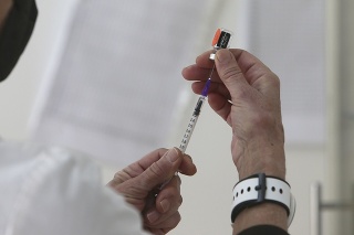 Zdravotná sestra naťahuje injekčnou striekačkou vakcínu proti ochoreniu COVID-19 od spoločností Pfizer-BioNTech