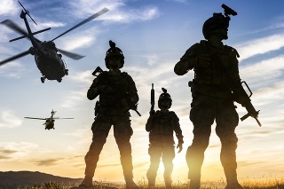 Squad of Three Fully Equipped and Armed Soldiers Standing on Hill  at sunset