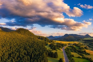 Aerial view of a road going through forests of the Liptov region in Slovakia at sunset.