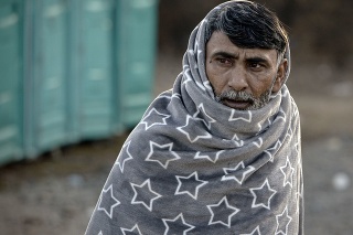 Bosna: Migrant sa chúli v deke, aby sa ochránil pred zimou. 