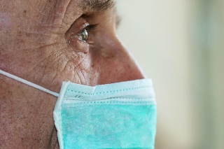face of elderly man wearing medical facemask health safety concept