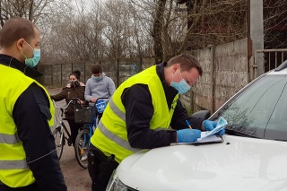 Mestskí policajti počas kontroly občanov, či majú certifikát s negatívnym výsledkom testu na ochorenie Covid-19, na ceste z mestskej časti Veľký Harčáš v Komárne