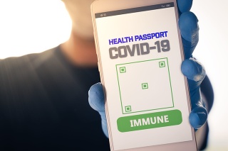 Man holding a smartphone with Immune digital passport for covid-19. Suitable for immunity passport app on the phone to monitorize the population movements at the end of the lockdown