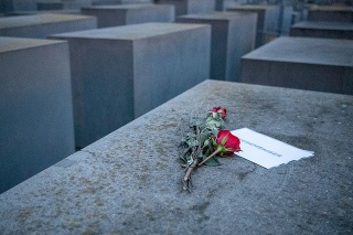 Ruže na kúsku papiera s nápisom „#Spomíname“ na pamätníku holokaustu v Berlíne
