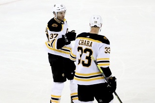 Na snímke vpravo slovenský obranca Bostonu Zdeno Chára, vľavo jeho spoluhráč v útoku Patrice Bergeron oslavujú gól v zápase hokejovej NHL New York Rangers - Boston Bruins 16. februára 2020.