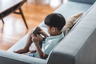 Chinese boy using smart phone in the living room