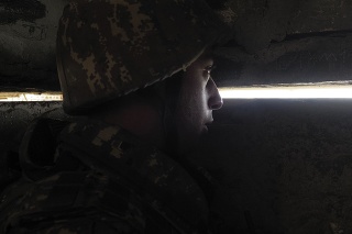 Arménsky vojak sa pozerá cez medzeru vo výkope smerom k azerbajdžanským pozíciám počas vojenského konfliktu v samozvanom regióne Náhorný Karabach.