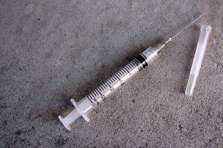 Syringe and needle on concrete floor