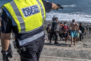 Migrantov, väčšinou z Maroka, eskortovali španielskou políciou po ich príchode na pobrežie Kanárskych ostrovov.