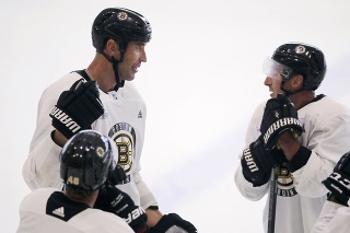 Obranca Bostonu Bruins Zdeno Chára (vľavo) sa rozpráva so spoluhráčmi.