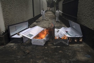 Pracovníci mexického krematória pália rakvy po obetiach COVID-19, ktoré boli spopoľnené.