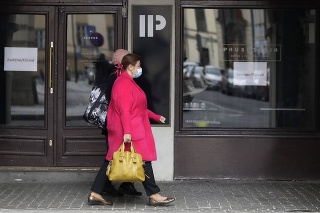  Ženy s ochrannými rúškami pri zatvorenej reštaurácii v Prahe.
