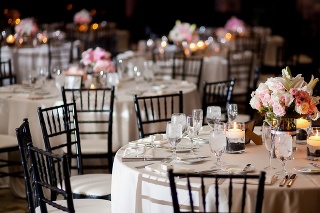 Multiple tables with centerpieces at an indoor elegant wedding reception