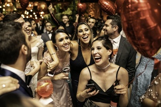 Groom and wedding guests laughing during party