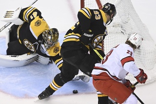 Na snímke zľava slovenský brankár Bostonu Jaroslav Halák kryje puk, uprostred jeho spoluhráč a slovenský obranka Zdeno Chára a vpravo krídelník Hurricanes Brock McGinn.