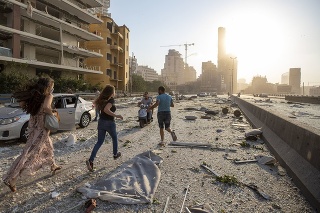 Ľudia utekajú po ulici po masívnych výbuchoch v prístave v libanonskom hlavnom meste Bejrút.