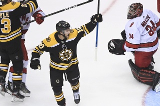 Ľavé krídlo Anders Bjork (10) z Bostonu Bruins sa teší z gólu spoluhráča vedľa brankára Caroliny Hurricanes Petra Mrázka.
