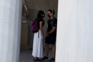 Turisti s ochranným rúškom na zabránenie šírenia infekcie koronavírusom. 