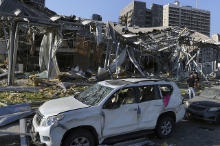 Ľudia pri zničených budovách po masívnych výbuchoch v prístave v libanonskom hlavnom meste Bejrút 