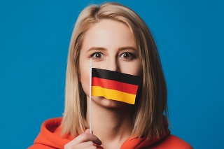 beatiful girl holds flag of Germany on blue background