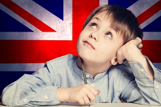 Thinking child boy student look up on the UK flag background. English concept