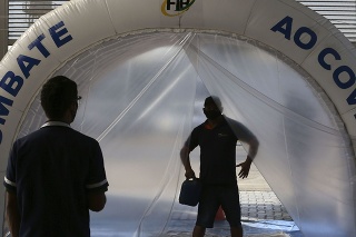 Muž prechádza dezinfekčným tunelom uprostred pandémie COVID-19 v Brazílii. 