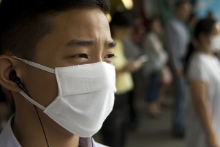 Focus on the eye of an Asian teenager. As we know, the young people are much more affected by the current swine flu. In the background also, a pregnant woman is visible wearing a mask.