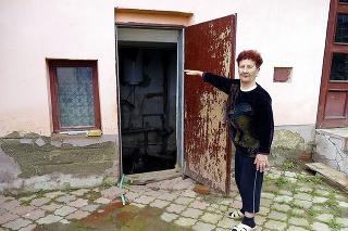 Dôchodkyňa Emília (73) ukazuje, pokiaľ siahala voda na dvore. 
