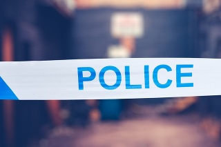British Police Tape Around A Crime Scene In A Grungy Urban Alley