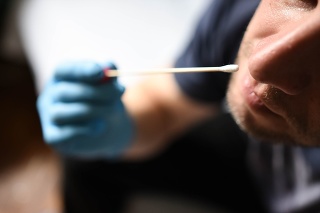 Man holding self testing self-administrated swab and medical tube for Coronavirus COVID-19, before being self tested at home or office