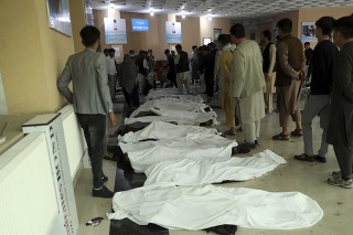  Afganskí muži identifikujú telá obetí po výbuchu bomby, ku ktorému došlo v blízkosti školy v afganskom hlavnom meste Kábul v sobotu 8. mája 2021.