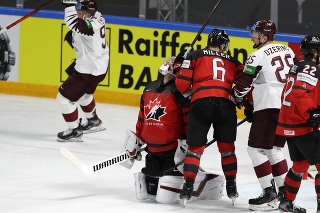 Lotyšský hokejista Miks Indrasis (vľavo) sa teší z gólu brankárovi Kanady Darcymu Kuemperovi.