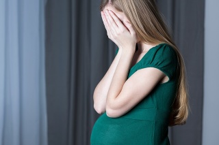Image of a pregnant teenage girl hiding her face in her hands