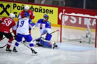 Na snímke vpravo brankár Július Hudáček (Slovensko) inkasuje druhý gól, vľavo Dario Simion (Švajčiarsko) v zápase základnej A-skupiny Švajčiarsko - Slovensko na 84. majstrovstvách sveta v ľadovom hokeji v lotyšskej Rige.